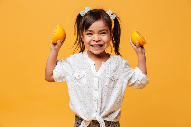 Маленькая девочка ребенок держит апельсин.