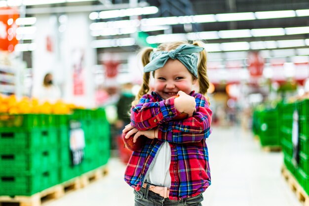 Little girl choosing an apple in a food store or a supermarket