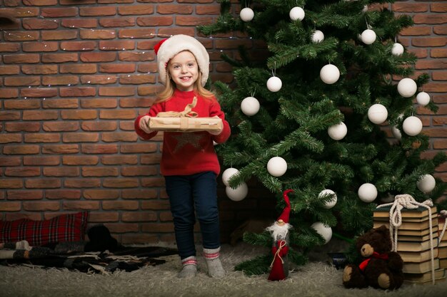 Маленькая девочка на Рождество с подарочной коробке на елку