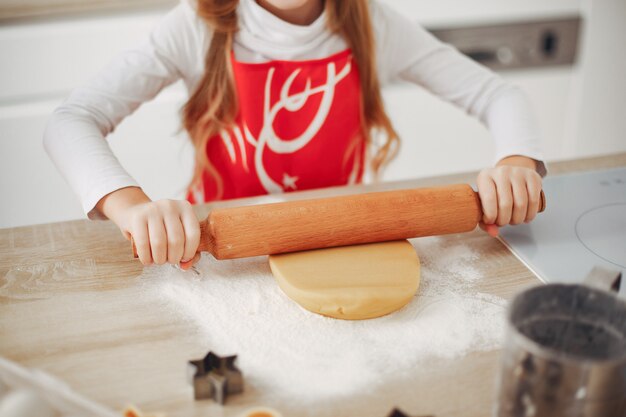 Little girl cook the dough for cookies