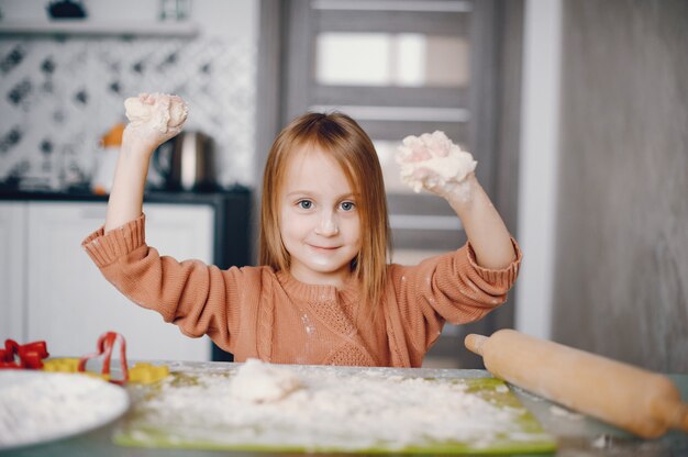 Little girl cook the dough for cookies