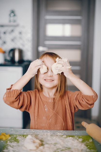 Free photo little girl cook the dough for cookies