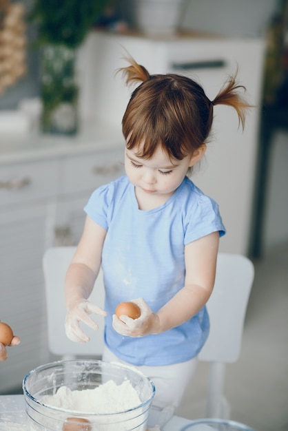 Free photo little girl cook the dough for cookies