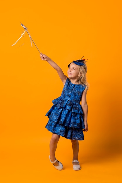 Little girl in costume with wand and mask