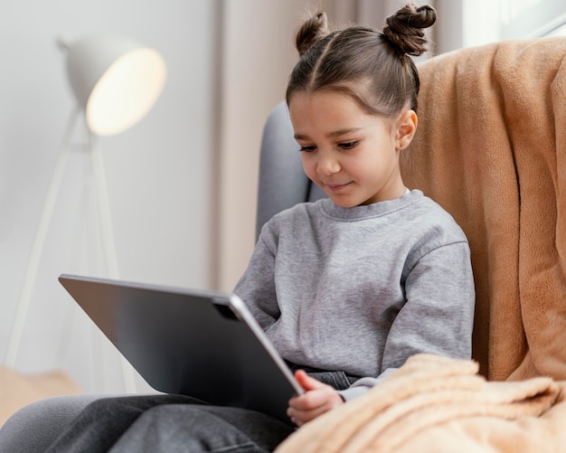 Little girl on couch using tablet