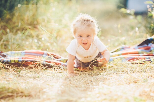 Маленькая девочка ползет по лужайке на ферме