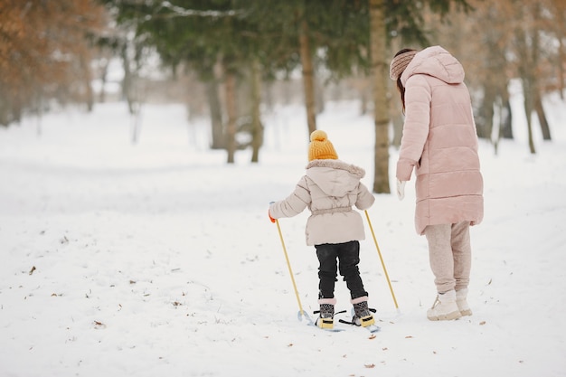 Little girl cross-country skiing with her mother