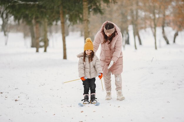 Little girl cross-country skiing with her mother