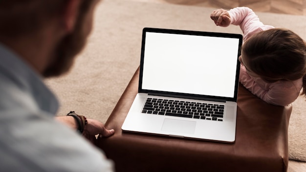 Little girl and dad spending time together next to laptop