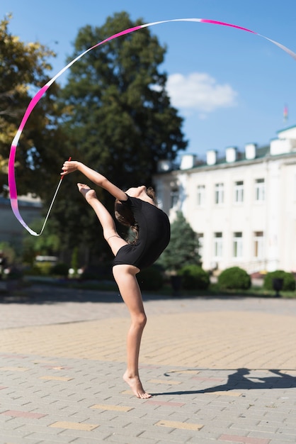 Free photo little girl doing gymnastics in park