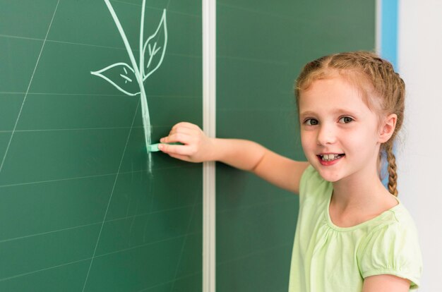 Little girl drawing on the blackboard