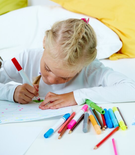 Little girl drawing at the table