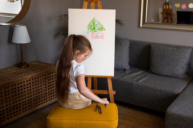 小さな女の子がスタッフで絵を描いている