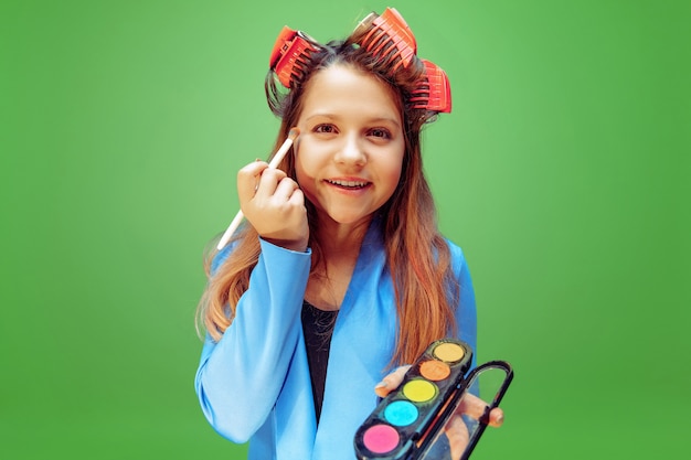 Free photo little girl dreaming about profession of makeup artist. childhood, planning, education and dream concept.