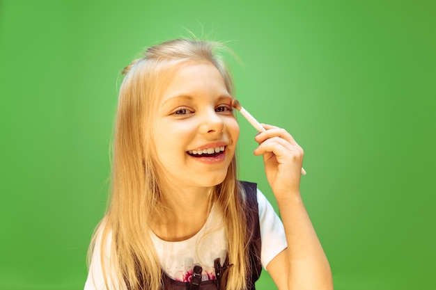 Free photo little girl dreaming about profession of makeup artist