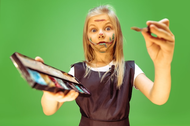 Little girl dreaming about profession of makeup artist