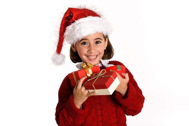 어린 소녀는 그녀의 손에 선물 산타 클로스로 옷을 입고
