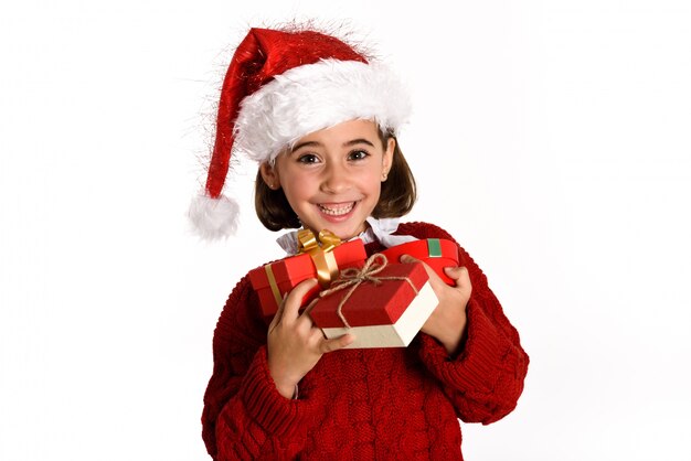 Little girl dressed as santa claus with a gift in her hands