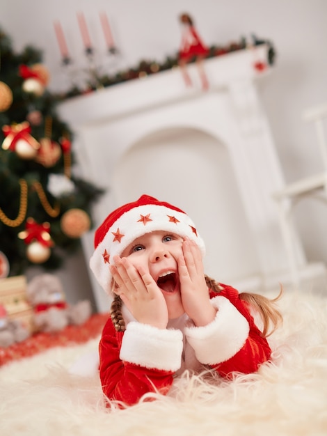 Little girl dressed in santa surprised