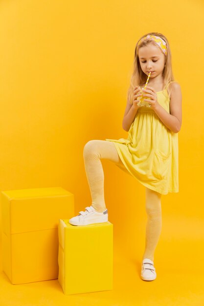 Маленькая девочка пьет лимонад