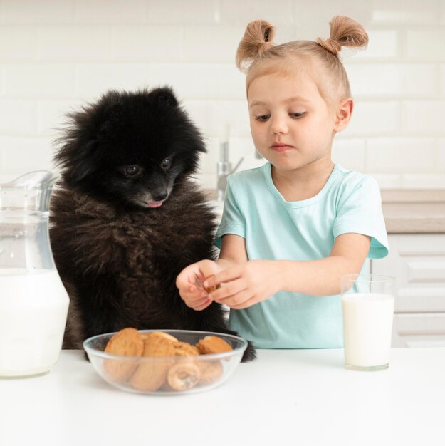 牛乳を飲むと犬と遊ぶ少女
