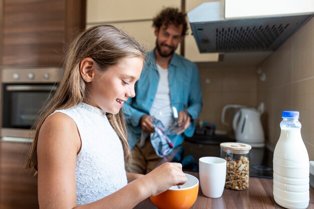 Little girl eating cereals in kitchen