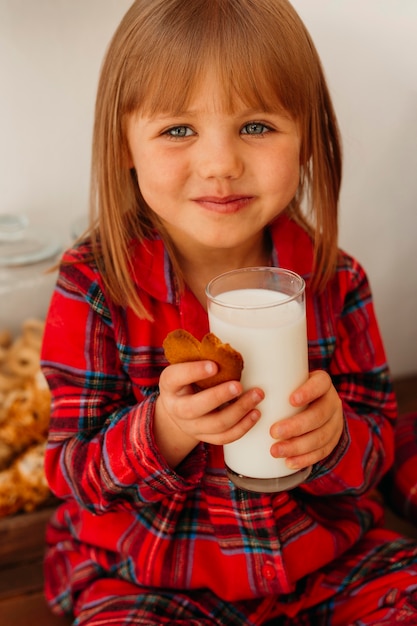 無料写真 クリスマスのクッキーを食べて牛乳を飲む少女