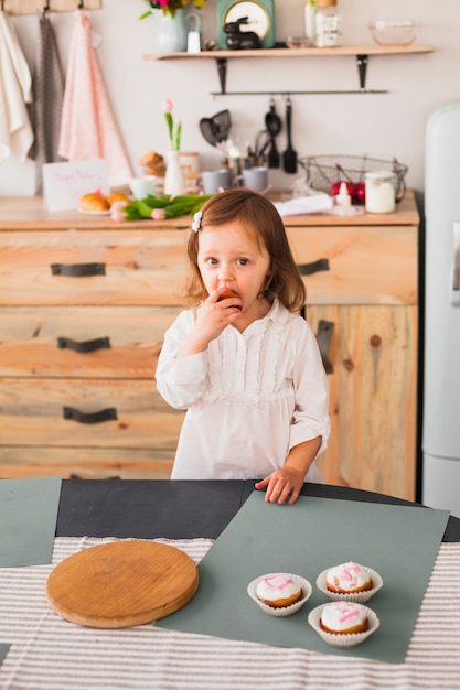 Little girl eating cupcake