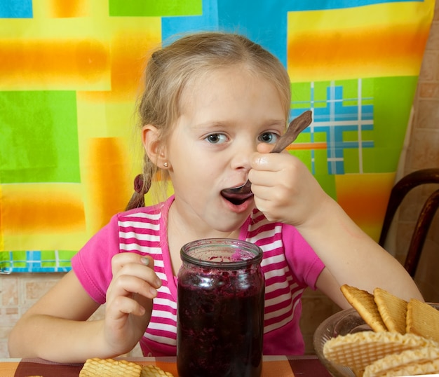 小さな女の子がジャムを食べる