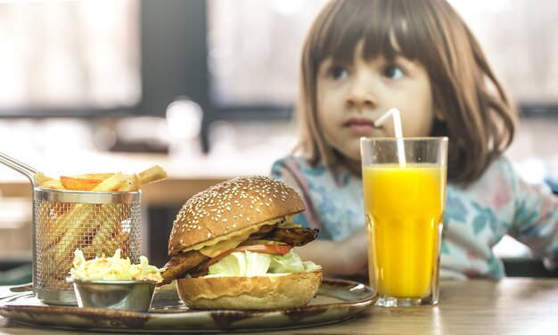 Little girl eats in a fast food cafe