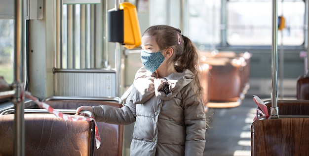 A little girl in an empty public transport during the pandemic coronavirus.