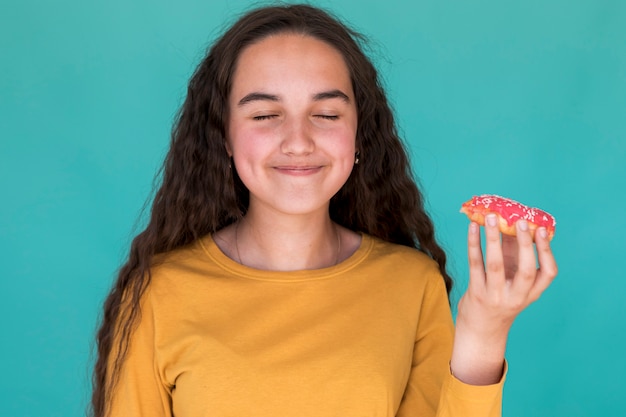유약 된 도넛을 즐기는 어린 소녀