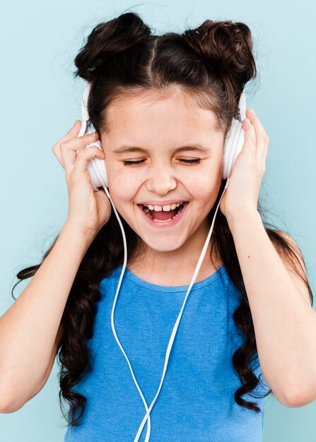 Little girl enjoying music at headphones