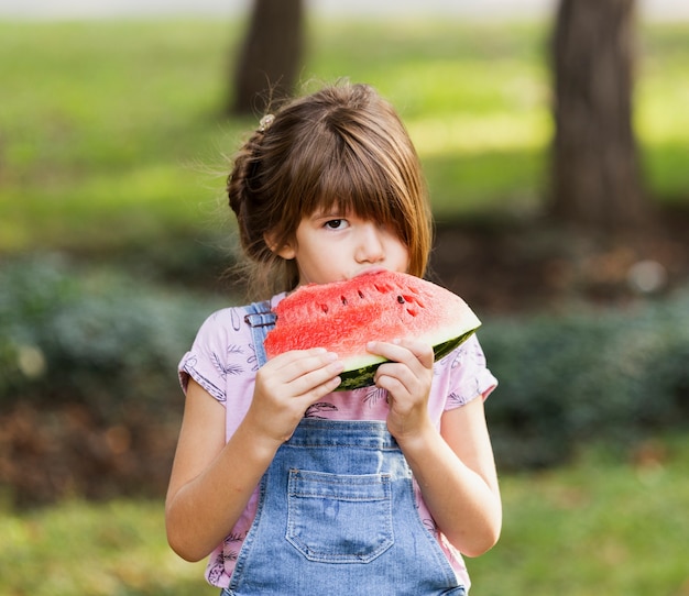 Little girl enjoying watermelon slice outside 
