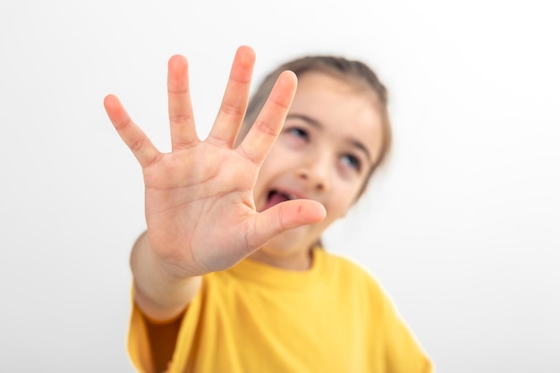 Free photo a little girl extends her hand to the camera closeup