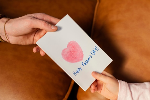 Free photo little girl giving her father a father's day card