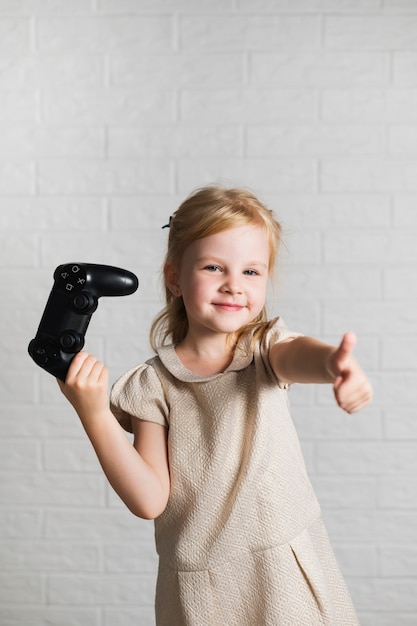 Free photo little girl giving ok sign for joystick