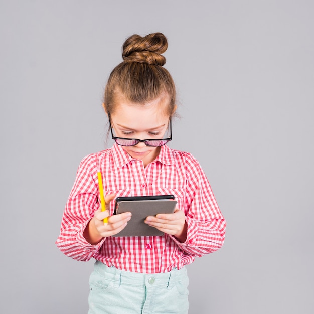 Foto gratuita bambina in vetri facendo uso della compressa