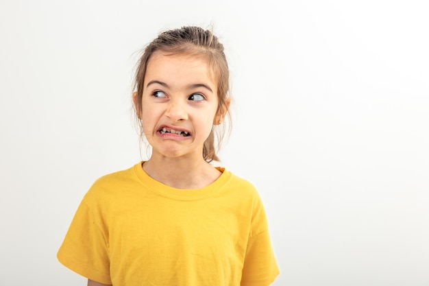 Free photo a little girl grimaces with displeasure on a white background isolated