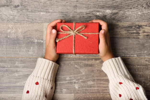 Little girl hands holding gift box 