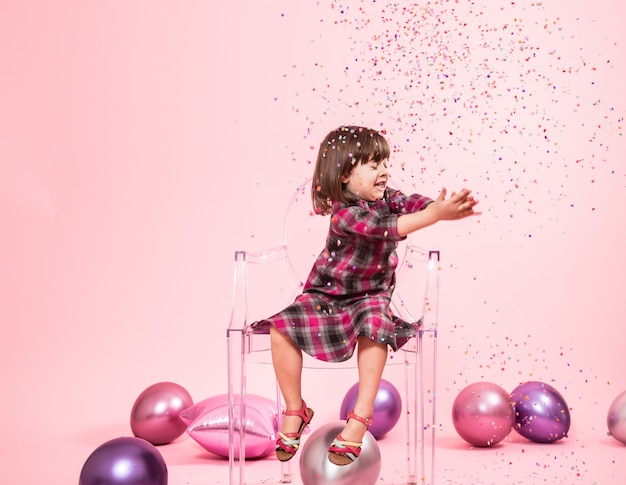 Бесплатное фото Маленькая девочка с удовольствием с конфетти. концепция праздника и веселья.