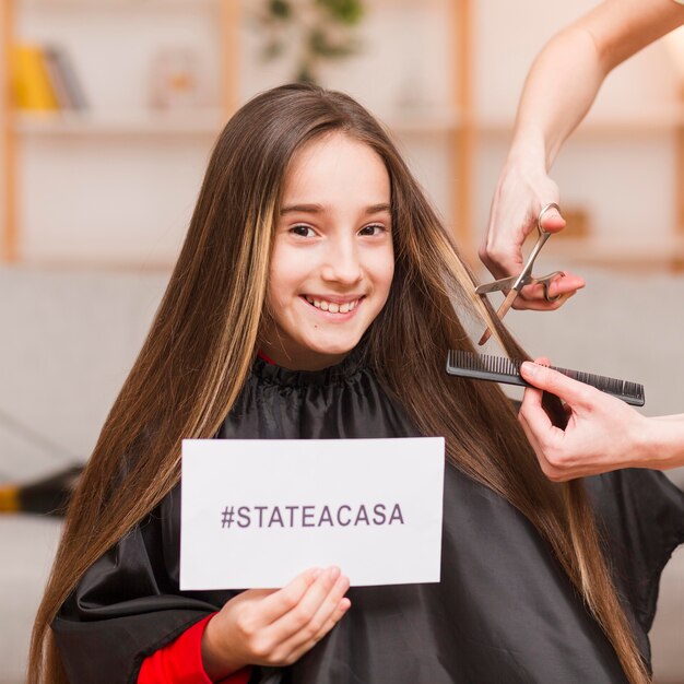 Little girl having haircut at home