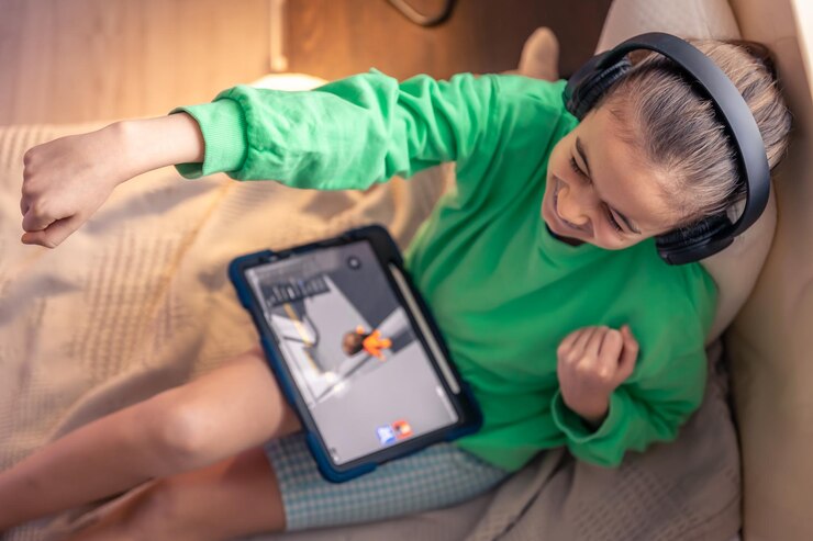 Free Photo little girl in headphones with a tablet in her room top view