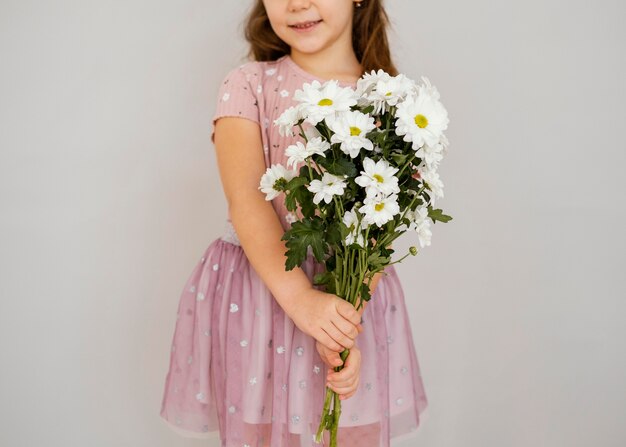 春の花の花束を持っている少女