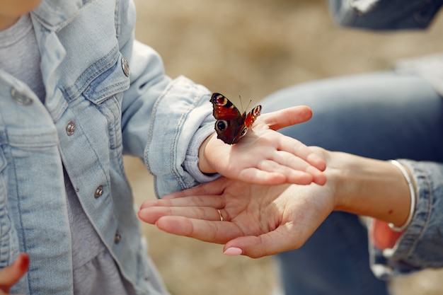 Маленькая девочка держит бабочку