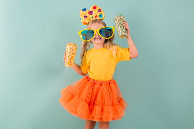 Little girl holding candy while wearing big sunglasses