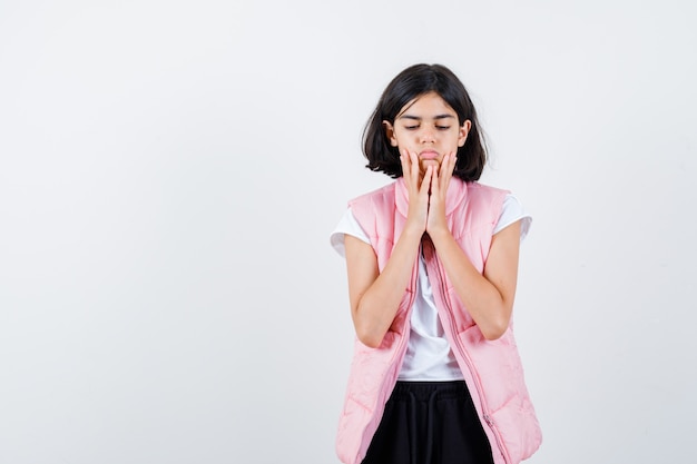 Little girl holding hands near mouth