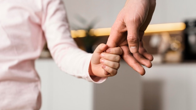Foto gratuita bambina che tiene le mani con il padre