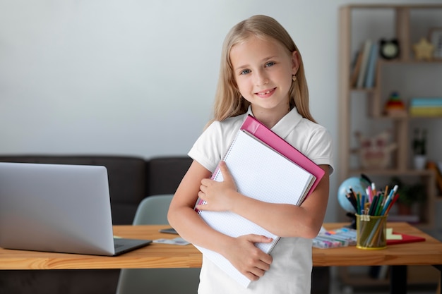 Bambina che tiene i suoi libri