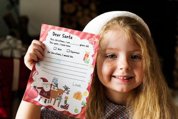 Bambina che tiene la sua lista dei desideri di natale